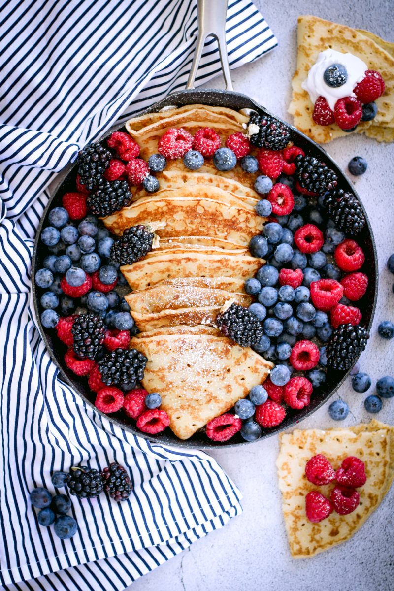 serving tray with folded crepes and fresh berries