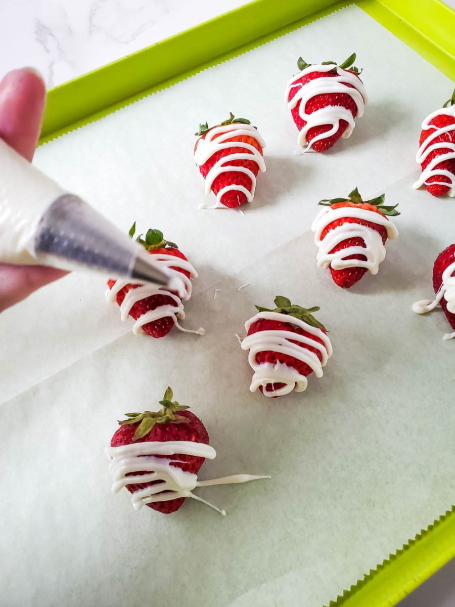 drizzling melted white chocolate over strawberries