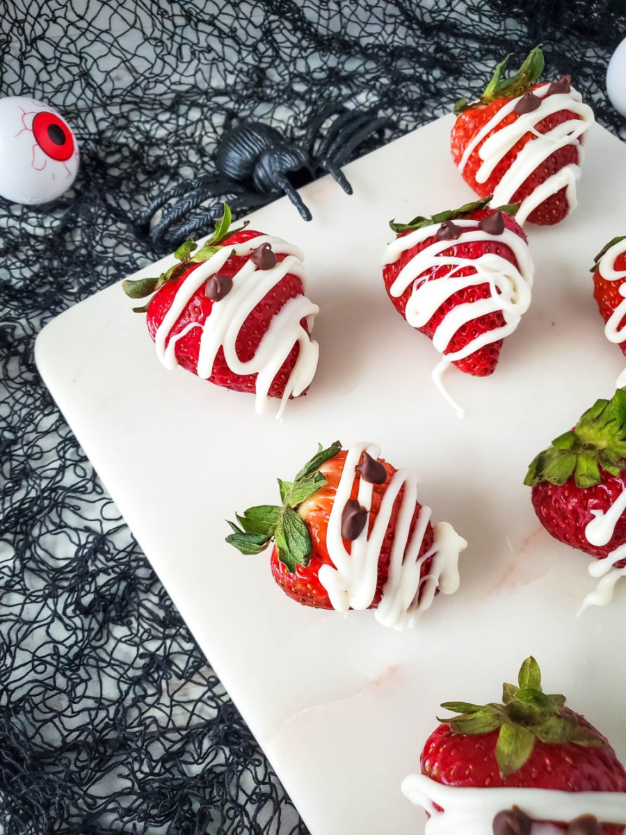 halloween strawberry mummies on plate with decor