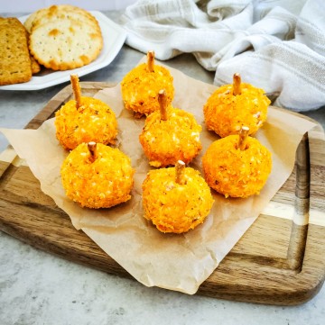 mini cheese balls shaped like pumpkins with crackers in the background