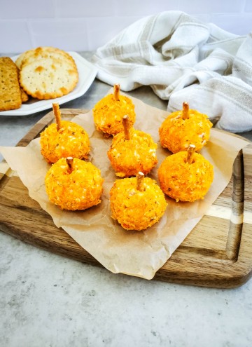 mini cheese balls shaped like pumpkins with crackers in the background