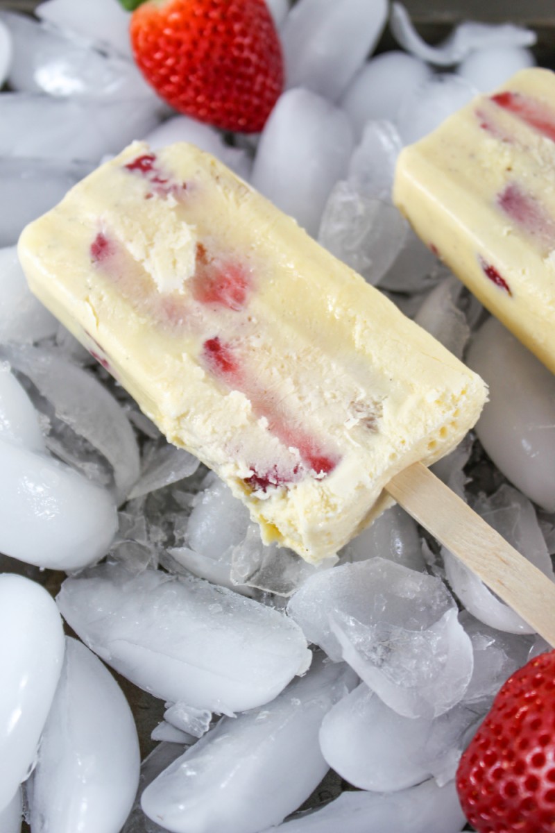 view of homemade strawberry and cream popsicle with ice cubes