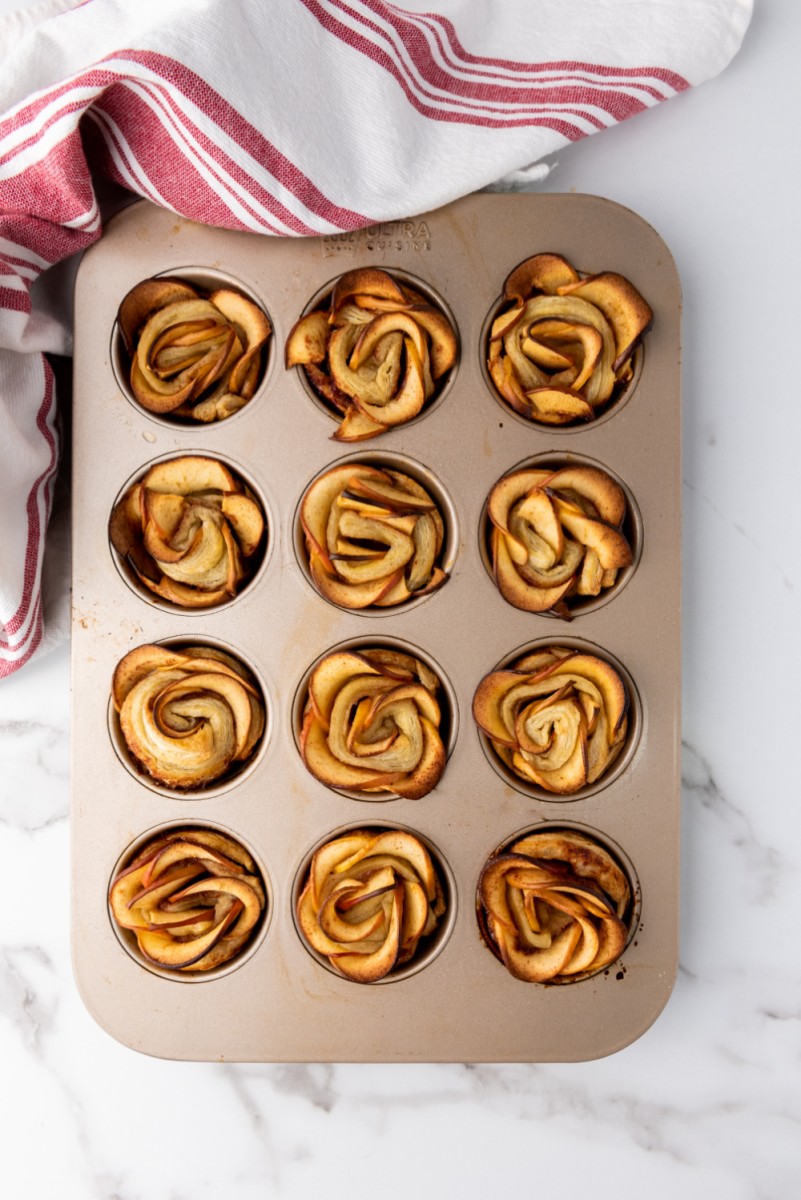 baked puff pastry apple roses cooling in muffin pan