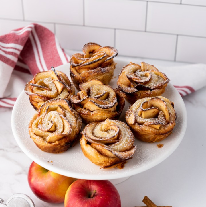 puff pastry apple roses dessert on platter with red and white towel