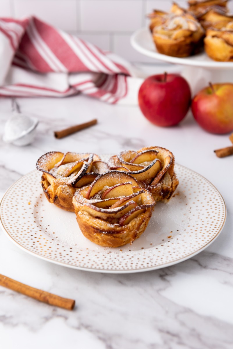 puff pastry apple roses dusted with powdered sugar and placed on plate