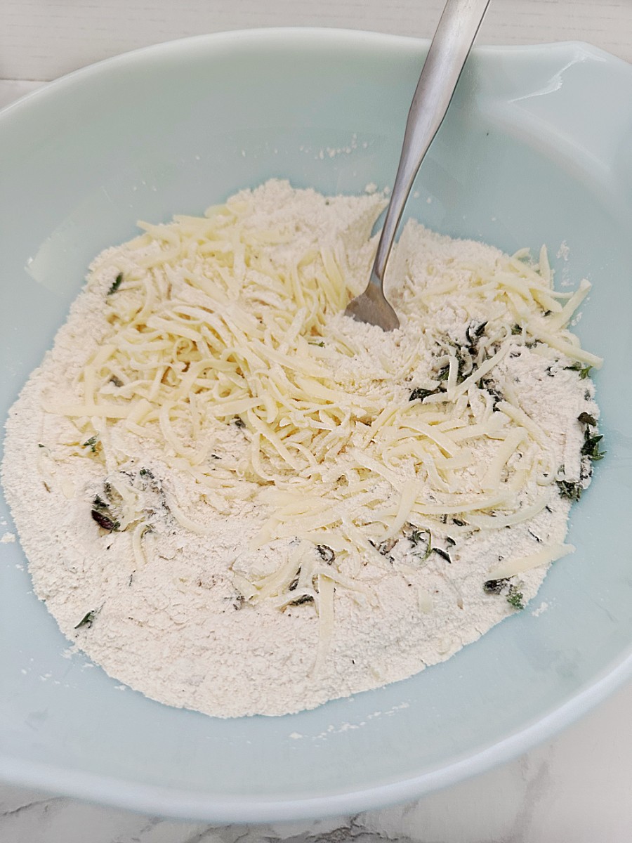 adding the provolone cheese and thyme to flour in bowl