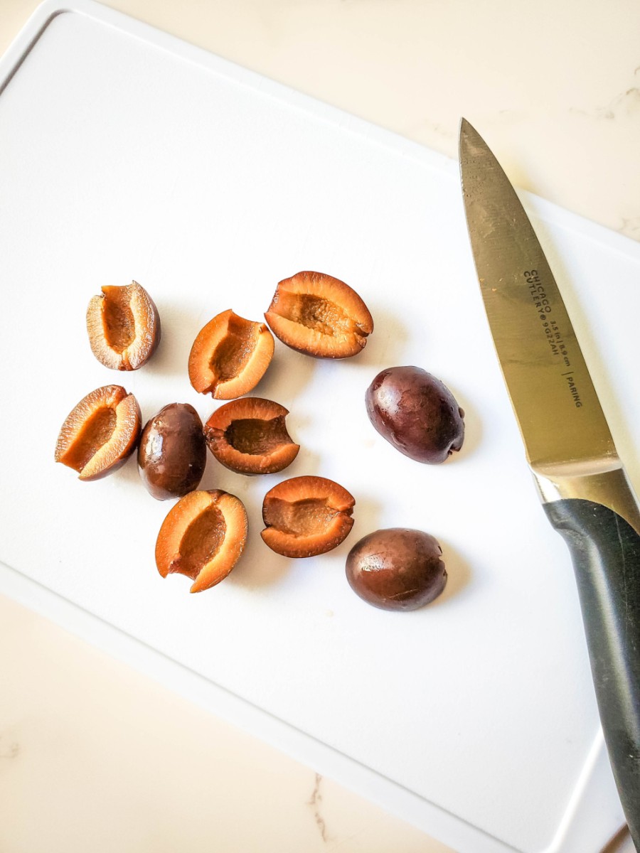 cut olives in half lengthwise with knife