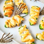 jalapeno poppers wrapped like mummies on white platter