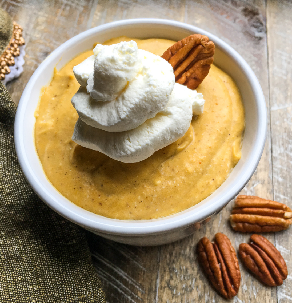 pumpkin mousse dessert with whipped topping in white bowl