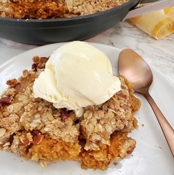 slice of apple crisp with scoop of ice cream on top