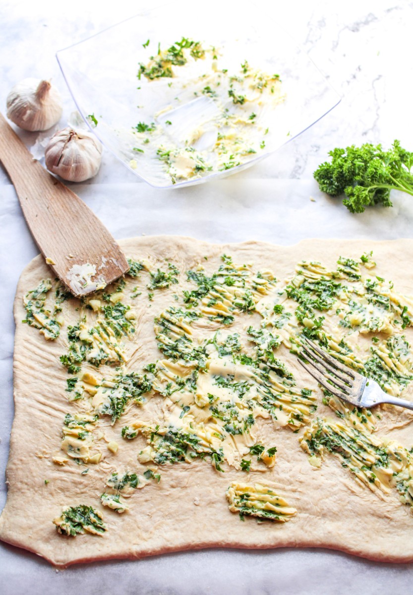 spread garlic parsley mixture on dough