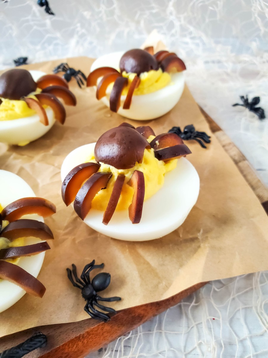 wooden board with spider deviled eggs for halloween