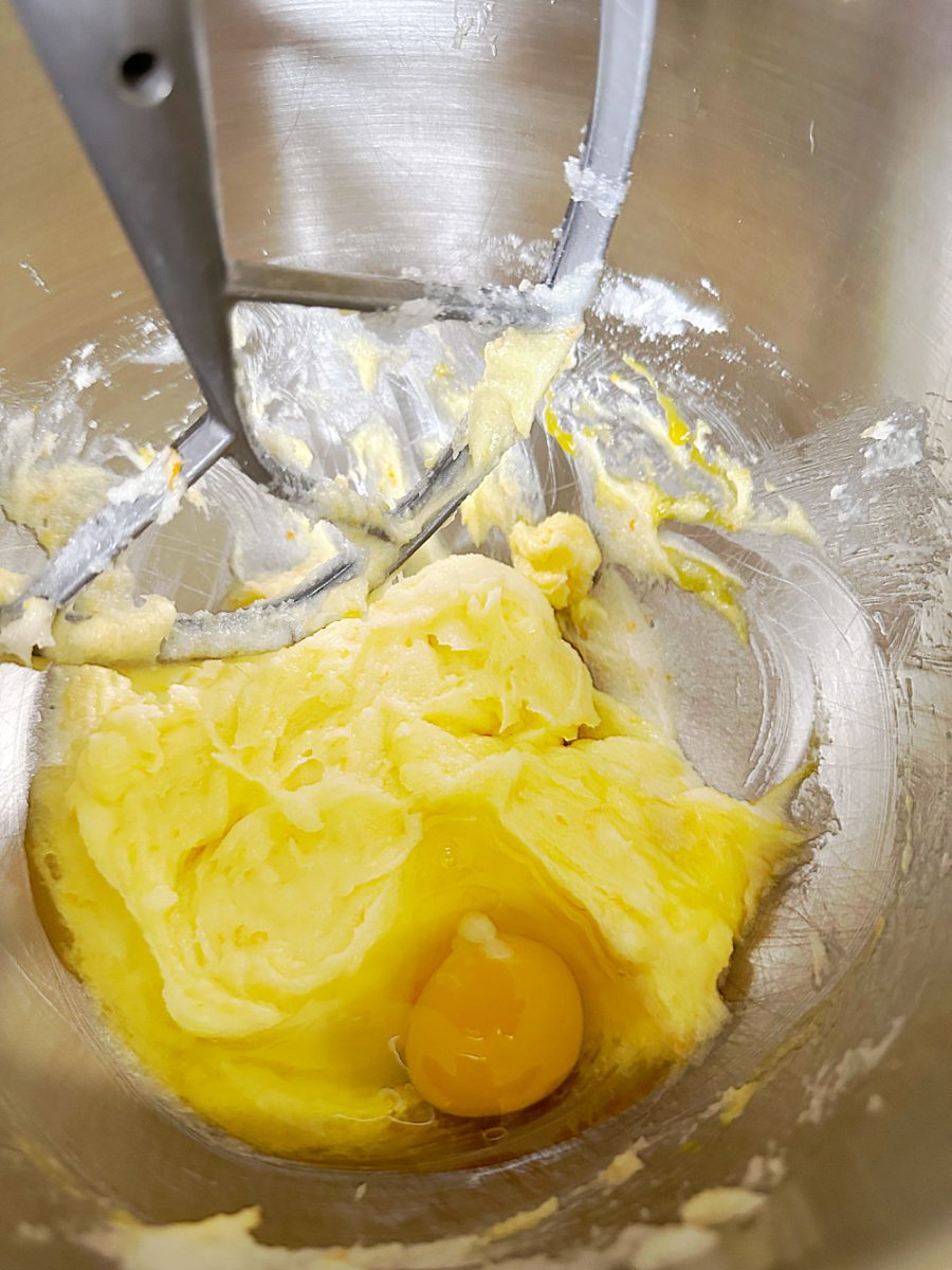 adding eggs and orange zest to cookie batter