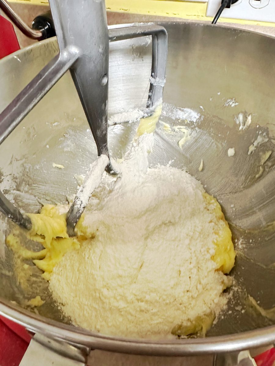 adding the flour mixture to the butter and egg batter in bowl