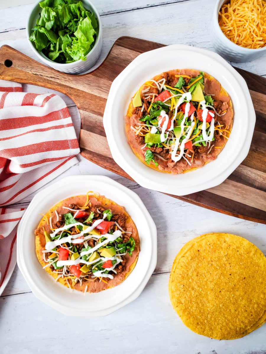 bean and beef tostadas on plates with toppings on the side