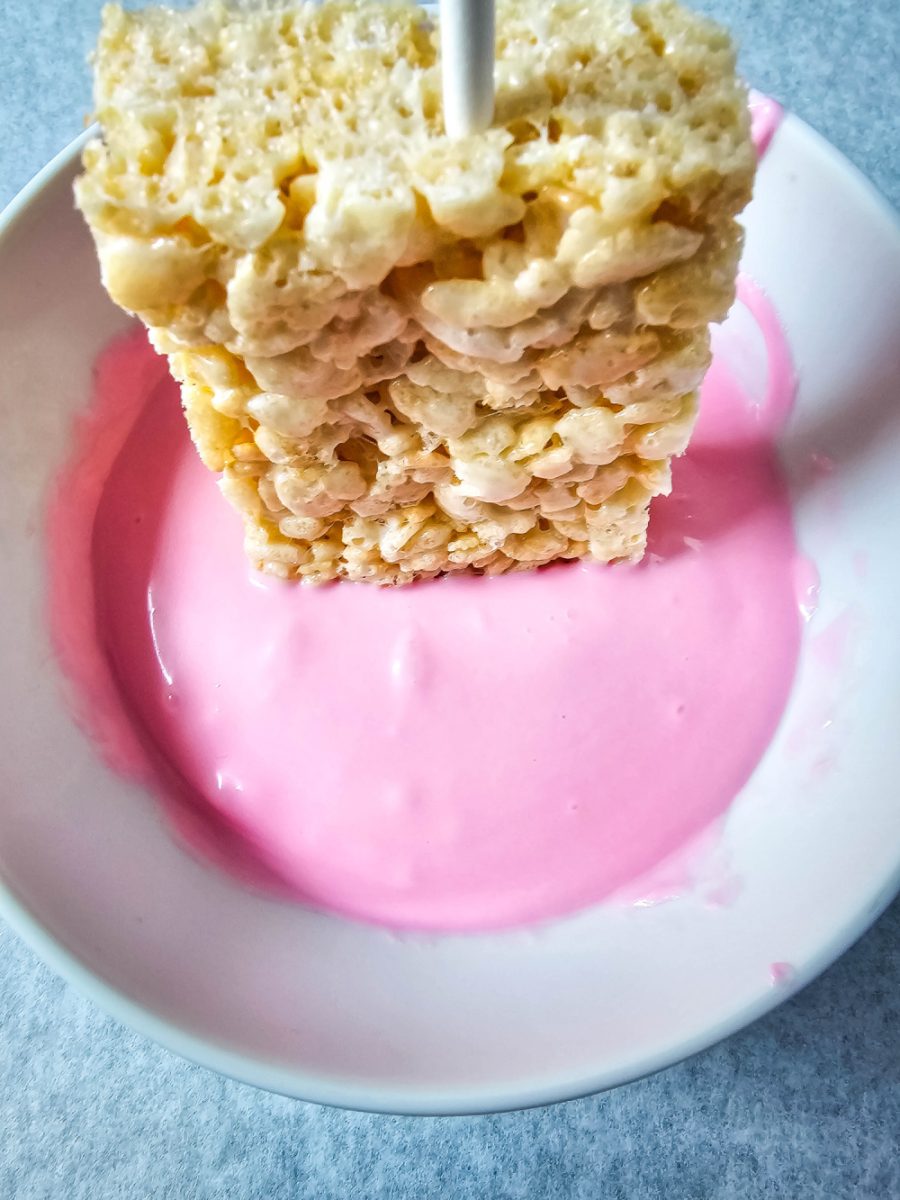 dip rice cereal treat into melted pink white chocolate