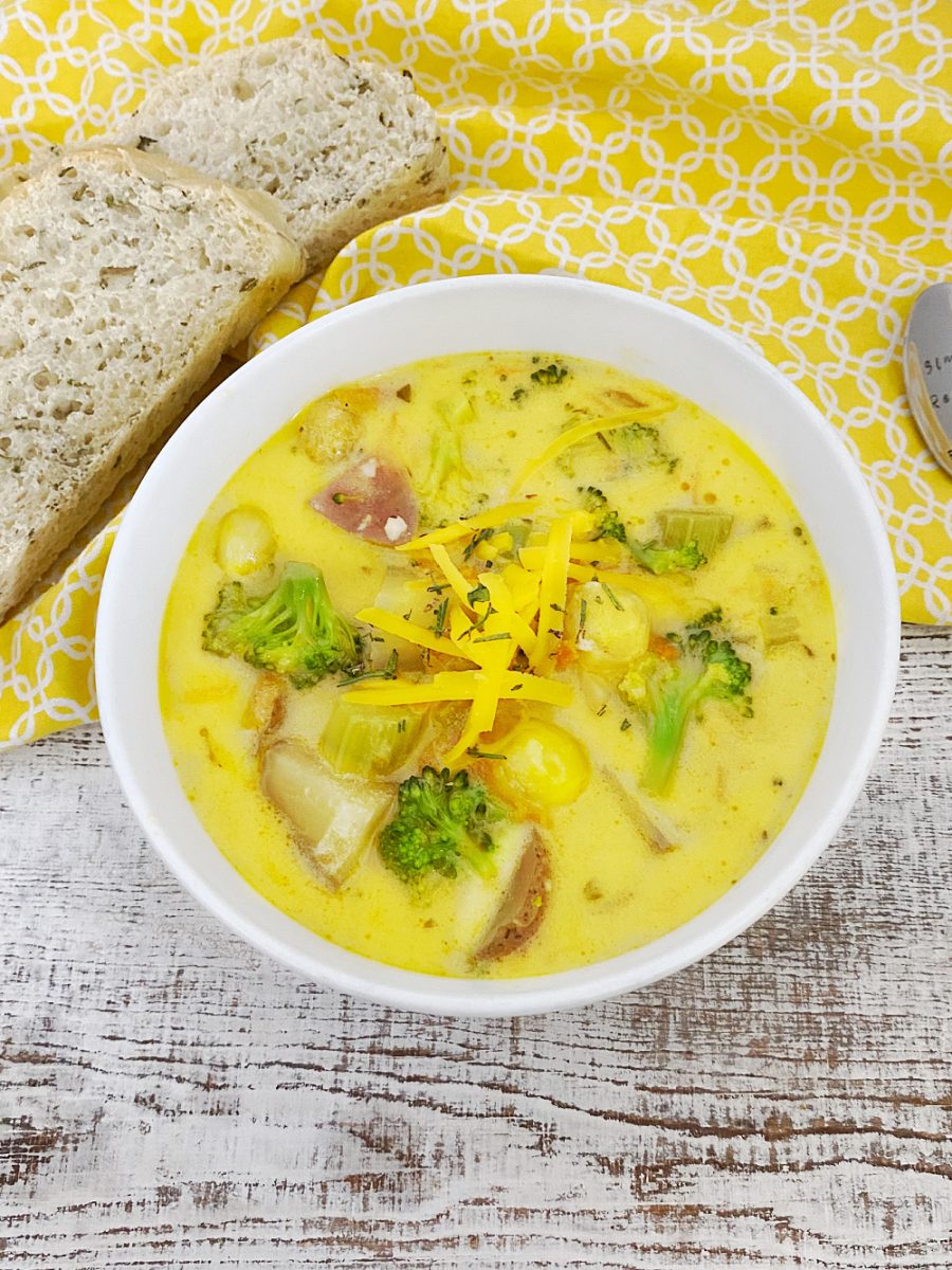 bowl of cheesy vegetable chowder with homemade bread