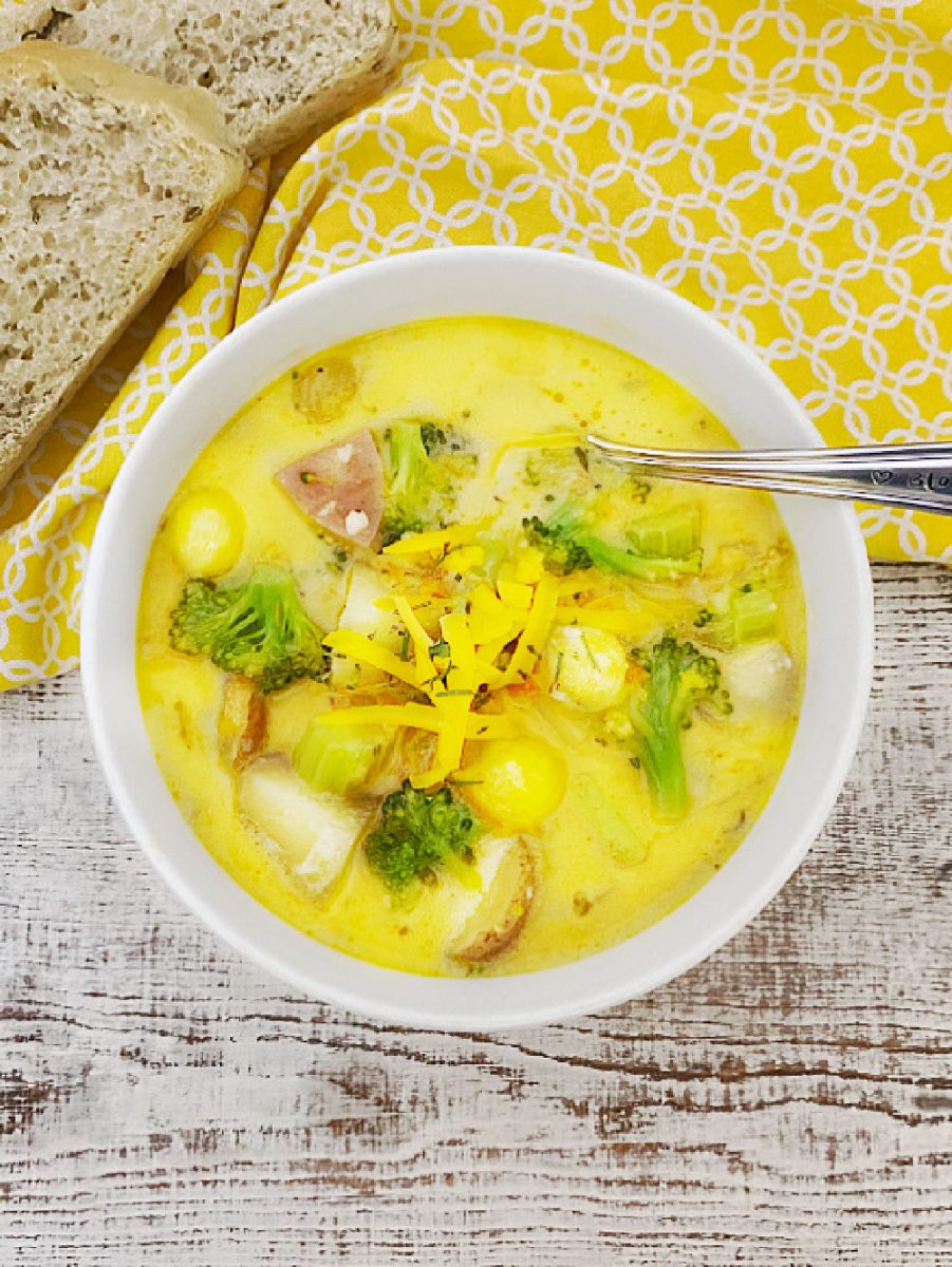 cheesy vegetable chowder in bowl with spoon