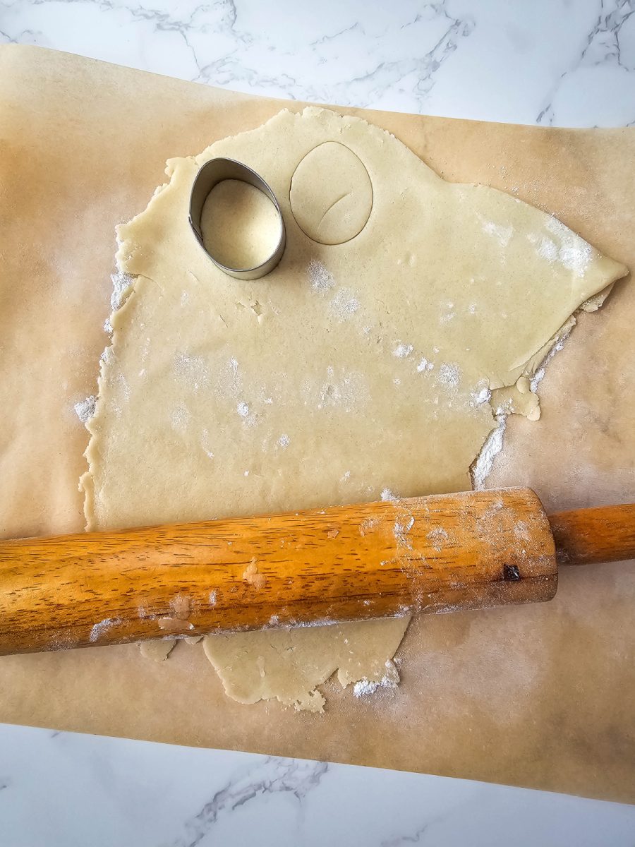 rolling out sugar cookie dough on floured surface