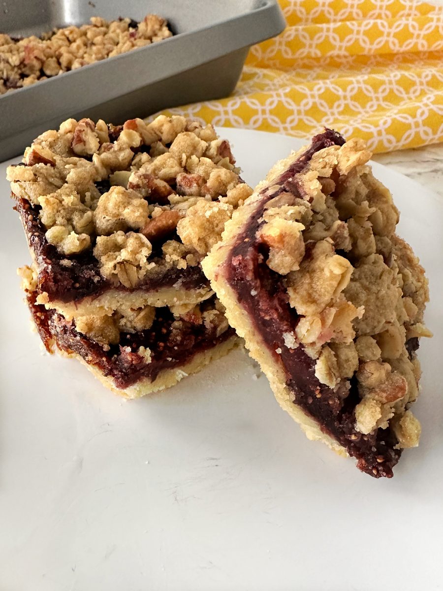 stack of homemade fig bars on plate with pan in background
