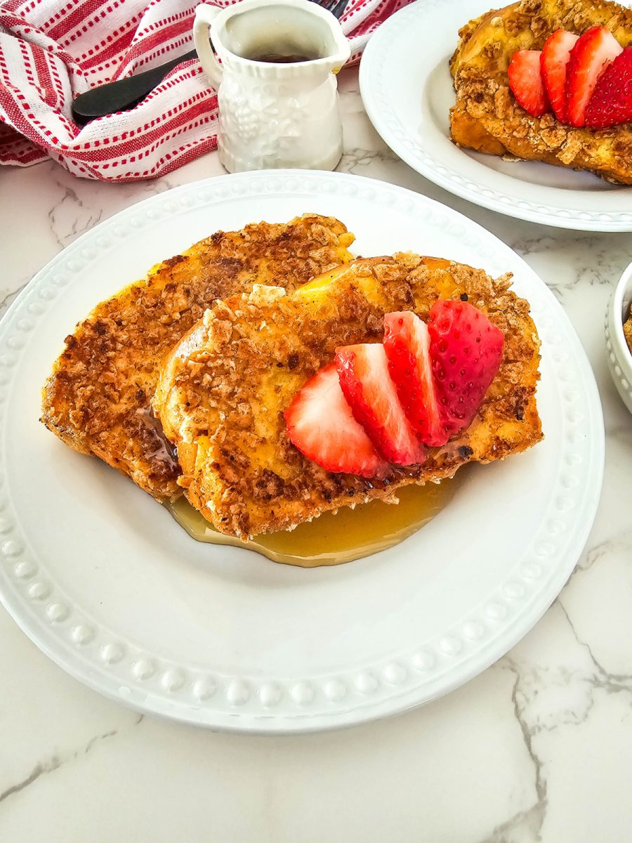 white plate filled with cinnamon crunch french toast and syrup