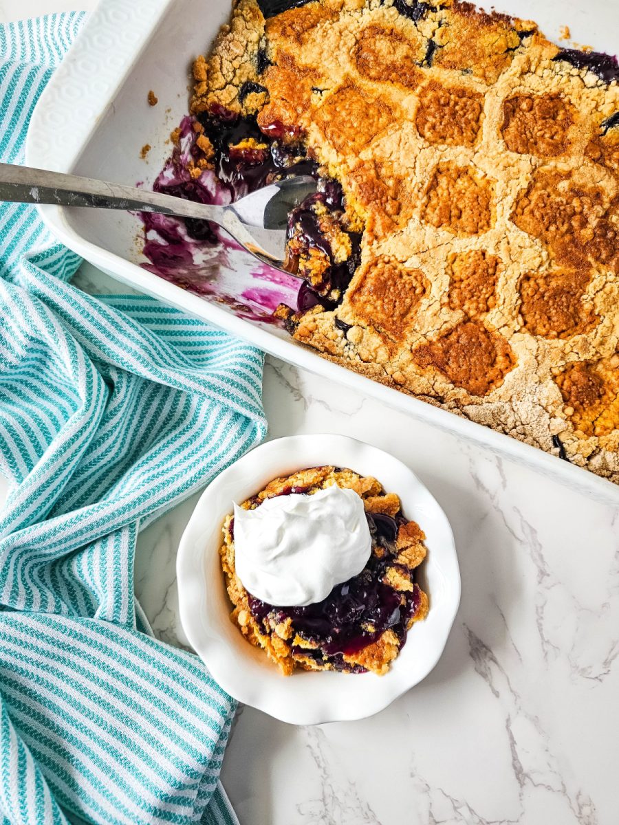 blueberry cobbler in dessert dish with whipped cream