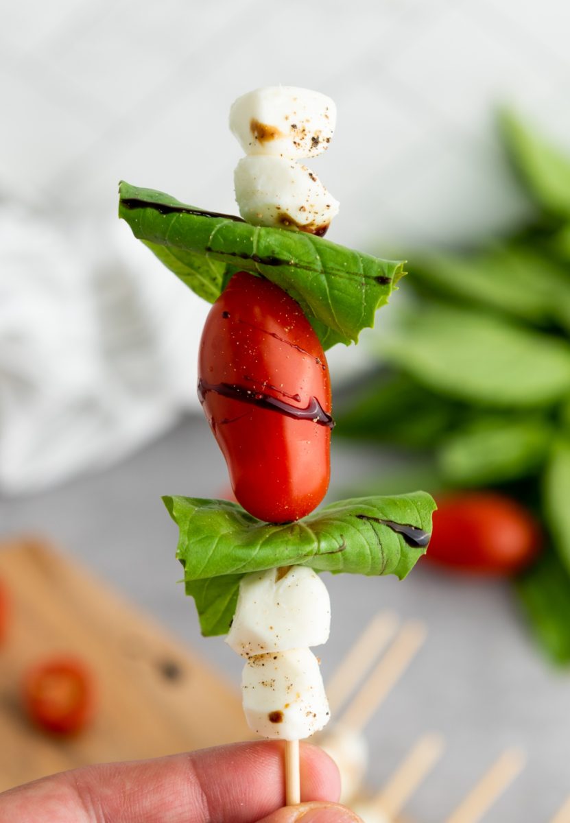 hand holding caprese appetizer