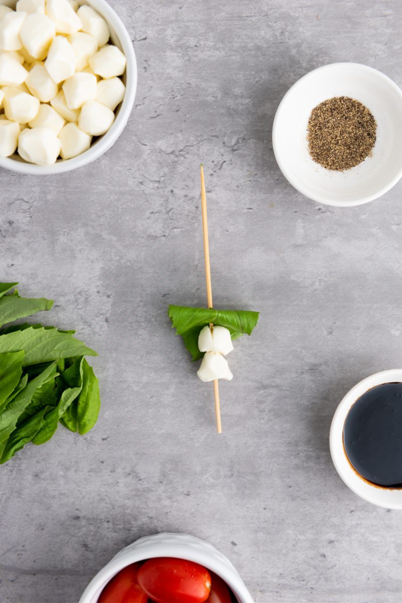 thread cheese and basil on skewer