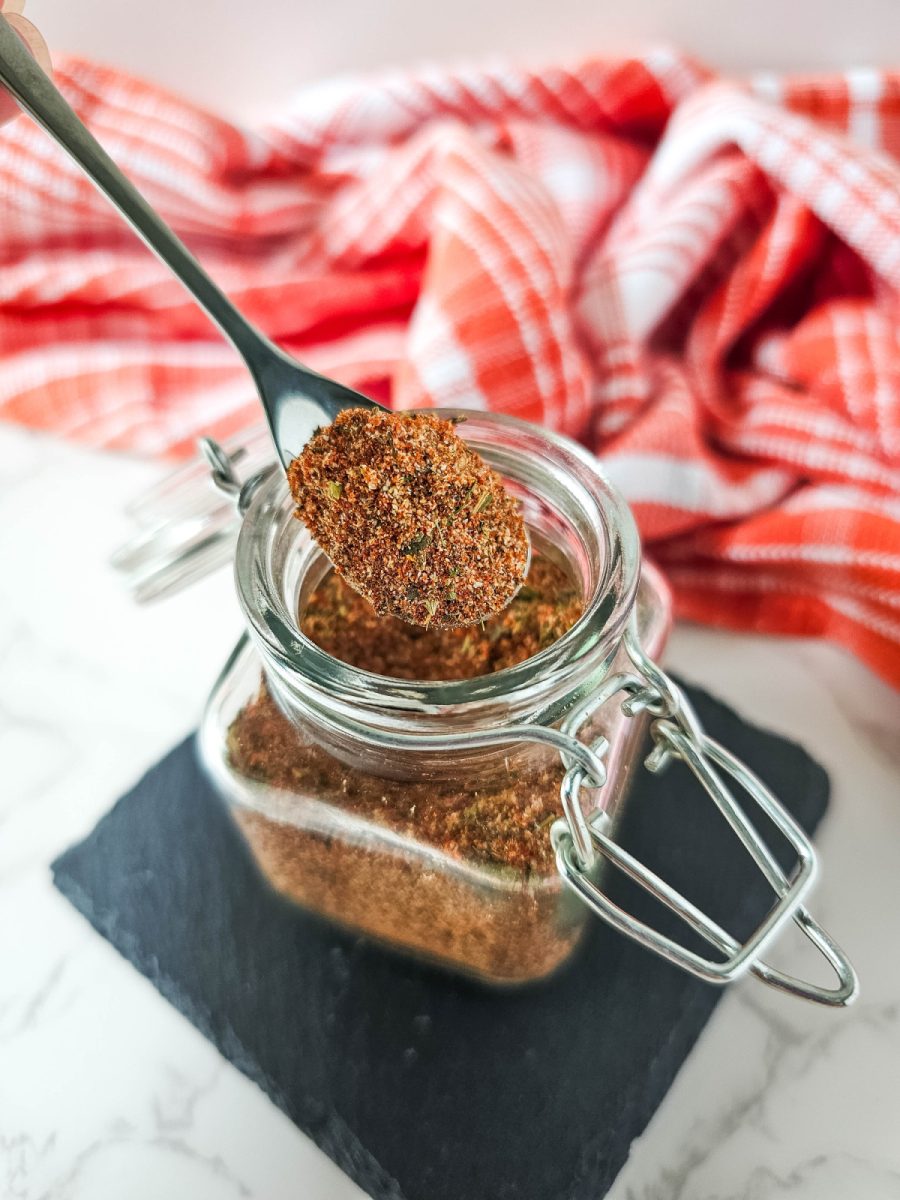 A close-up of a glass jar filled with a creole spice blend