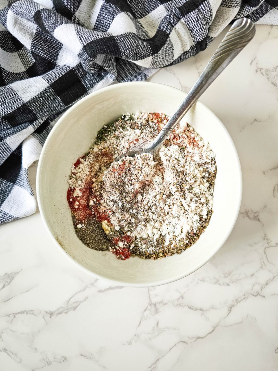 combine spices and herbs in bowl with spoon