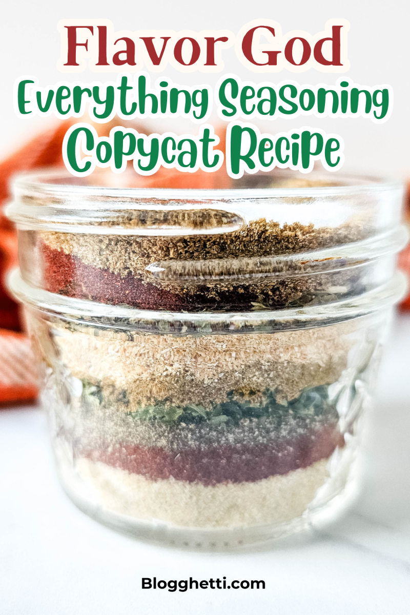 A mason jar filled with layered spices and herbs, creating a colorful and flavorful seasoning blend. The seasoning is a copycat recipe for Flavor God's Everything Seasoning.