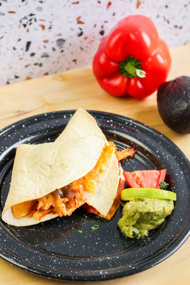 folded soft tacos on plate with guacamole