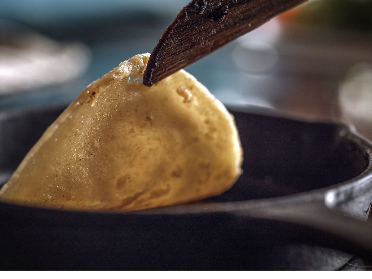 frying a corn torilla in pan