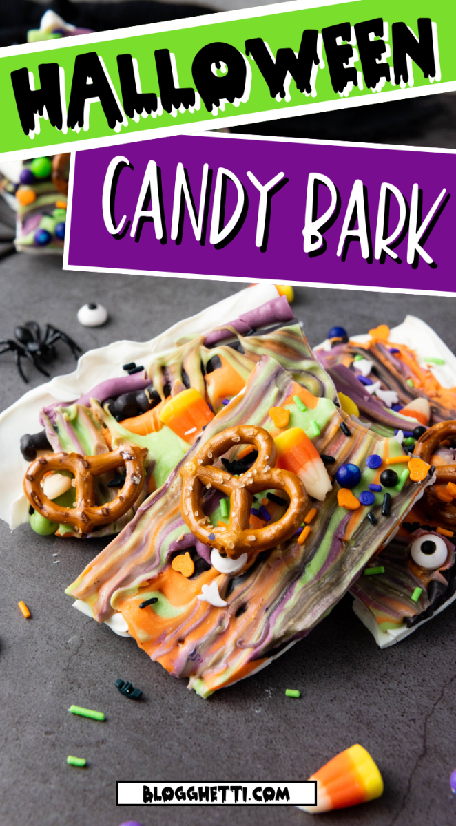 A plate of Halloween Candy Bark with various Halloween-themed candies, pretzels, and sprinkles. The bark is multicolored and broken into pieces. There are spiders and other Halloween decorations scattered around the plate.