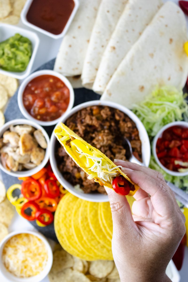 filling tortilla shell with cheese and other items