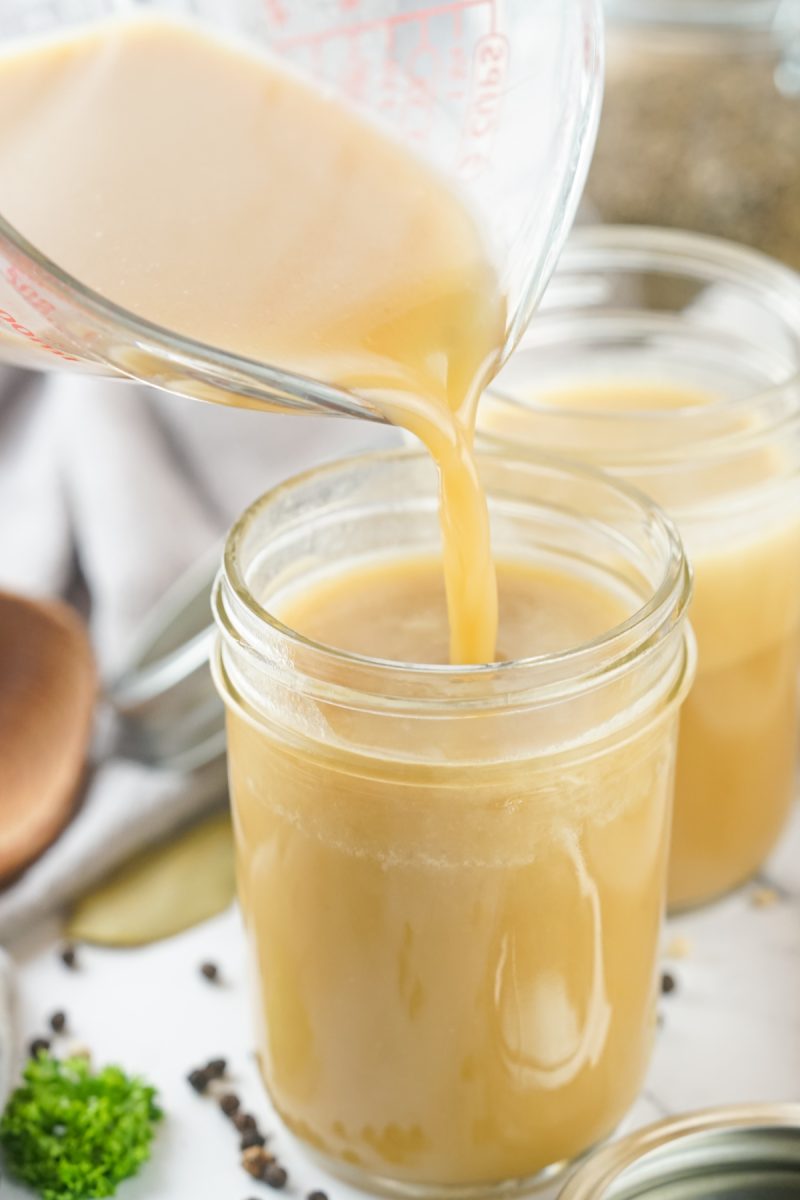 pouring stock into glass jar