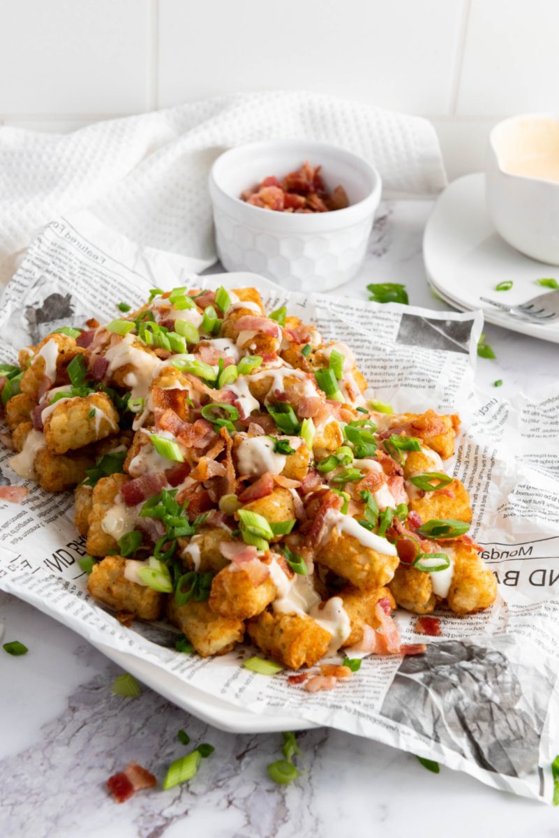 tater tots loaded with cheese and bacon in bowl