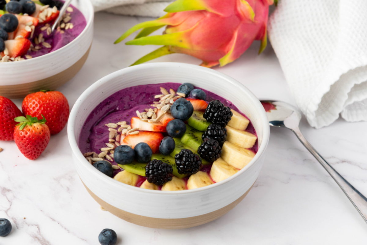 blended pitaya bowl with fruit in background