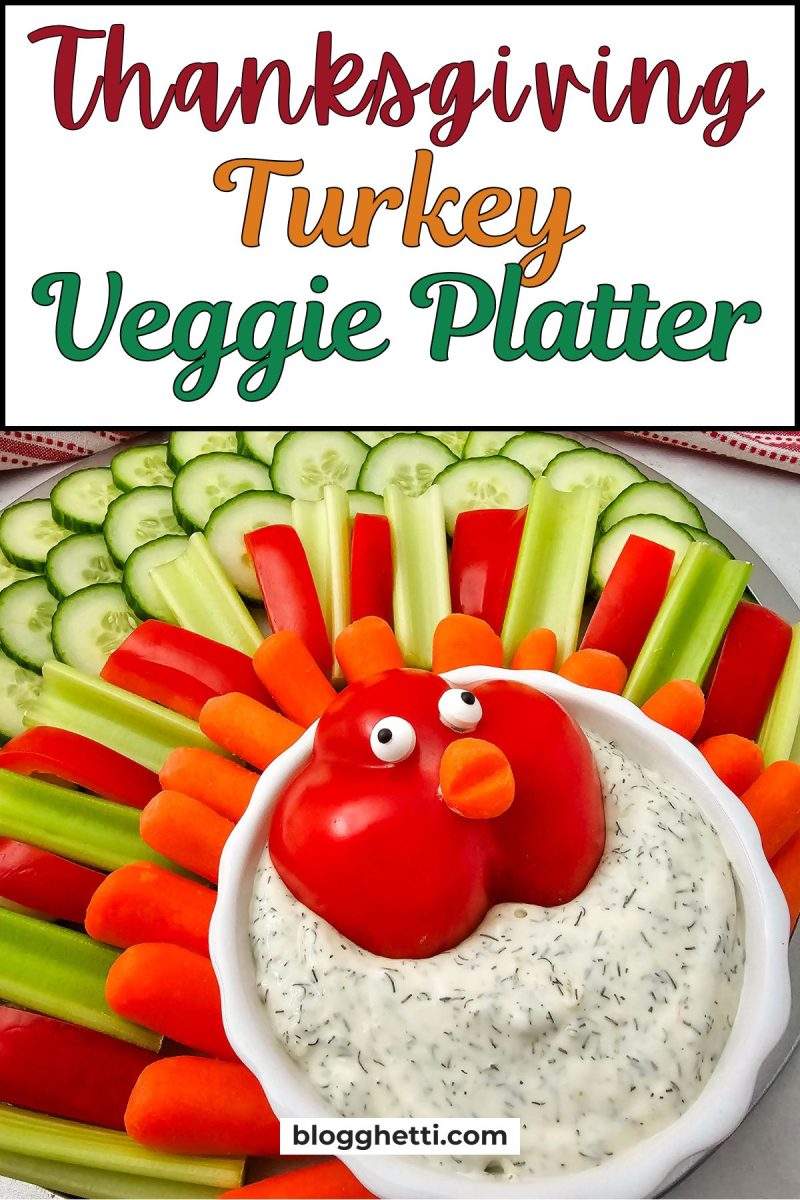 An overhead view of the completed Thanksgiving Turkey Veggie Platter with the title text "Thanksgiving Turkey Veggie Platter" overlaid. The platter features fanned layers of cucumbers, red peppers, celery, and carrots around a central bowl of dip with a red bell pepper turkey head.