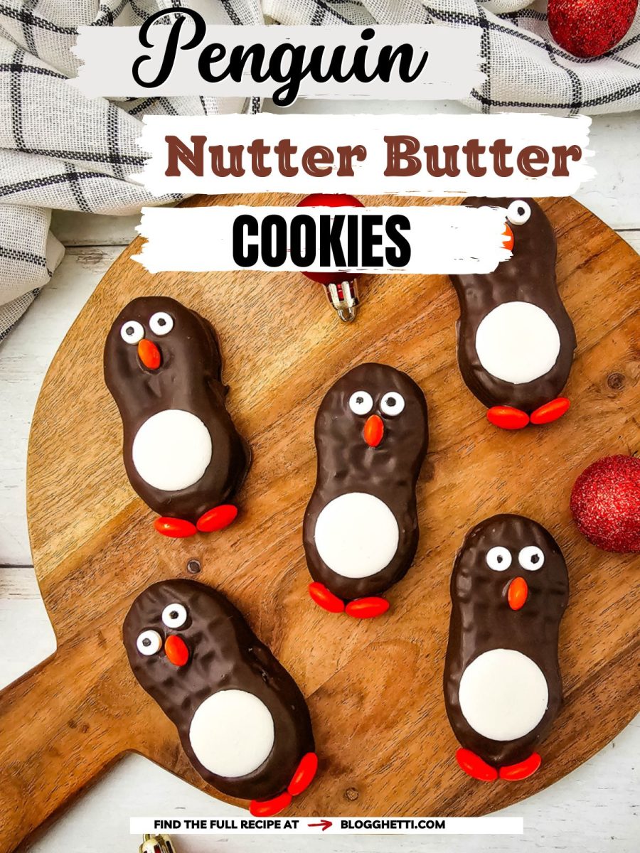 An overhead shot of five finished chocolate penguin treats displayed on a round wooden cutting board with a recipe title text overlay.