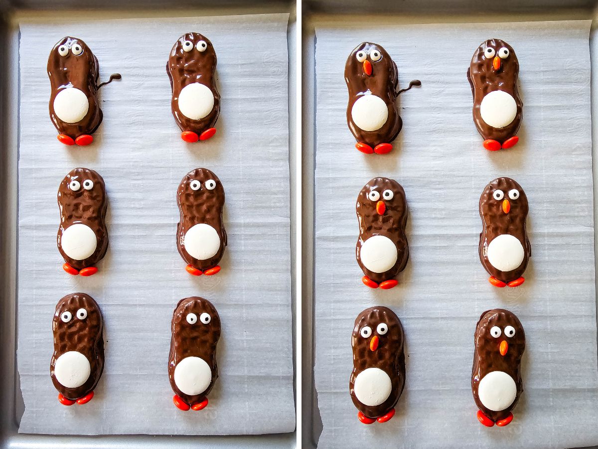 A baking sheet showing partially decorated chocolate treats being assembled. On the left, the peanut butter cookies have white bellies and orange feet. On the right, candy eyes and a mini orange beak are added.
