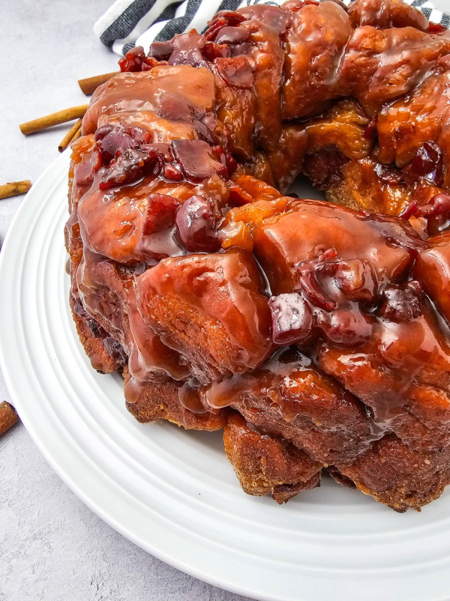 Close up view of the sticky maple glaze and crispy bacon bits coating the golden brown pull-apart bread.