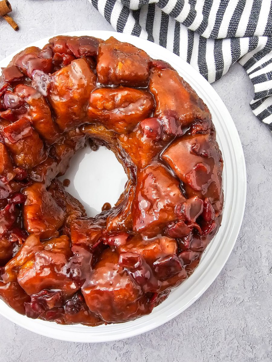 A detailed overhead shot focusing on the glossy texture of the cinnamon sugar and bacon coating each biscuit piece.