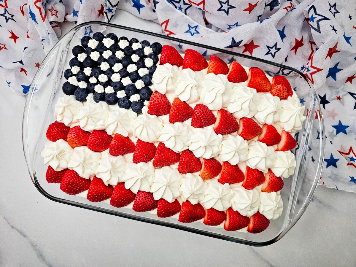 Fresh strawberries and blueberries arranged in a stars-and-stripes design on cake