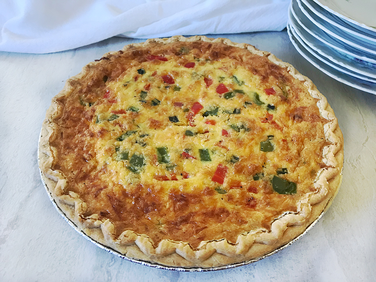 Deep-dish ham and vegetable quiche baked until golden brown in a flaky pie crust.