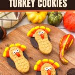 Three Nutter Butter Turkey Cookies with candy corn feathers and silly candy eyes sit on a wooden board surrounded by fall decorations. Text reads, “Candy Corn Turkey Cookies: Nutter Butter Turkey Cookies.”